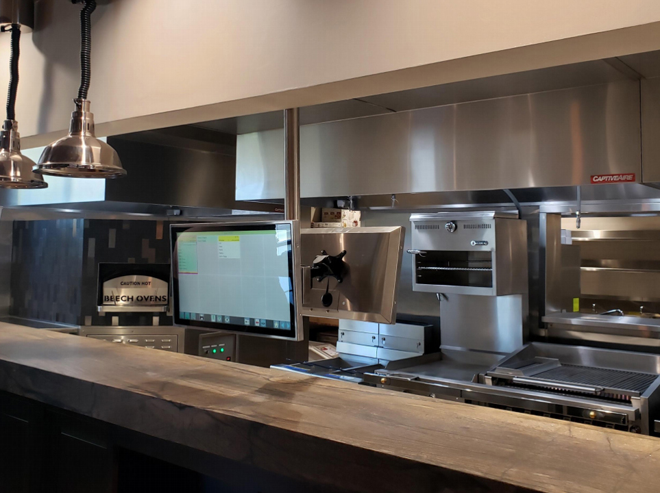 Kitchen Armor touchscreen installed beside stainless cooking equipment